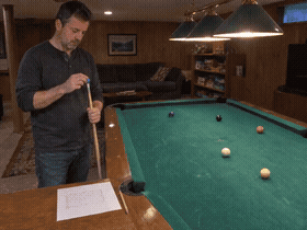 A player chalking his cue before a practice session